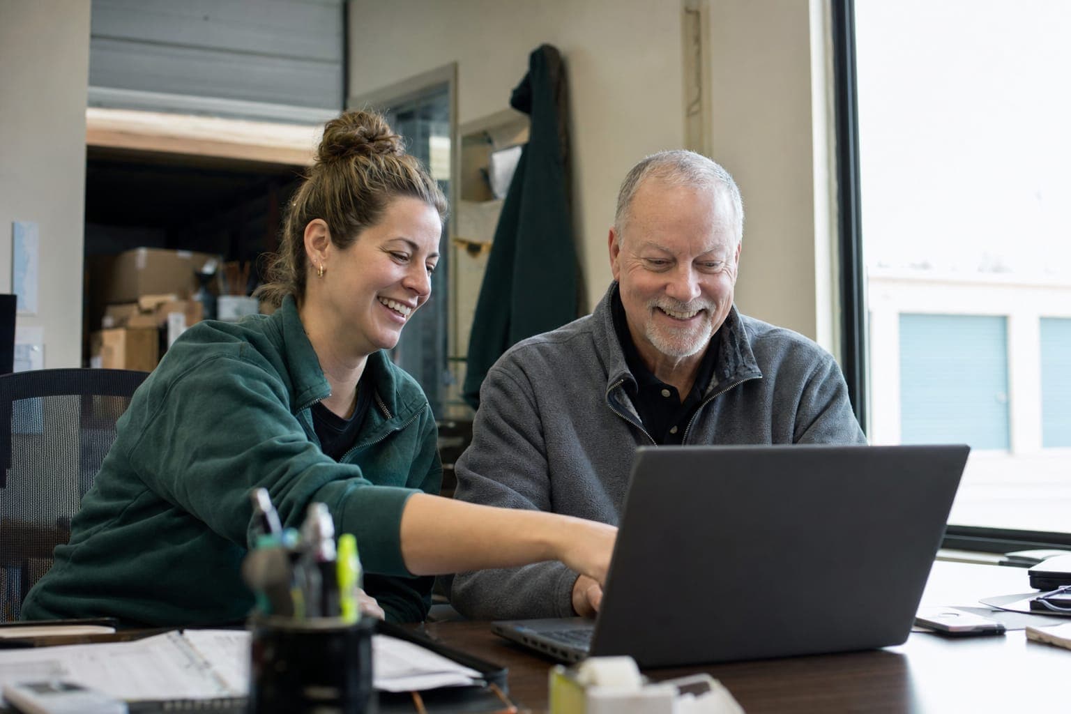 Two storage facility staff members working together on a laptop