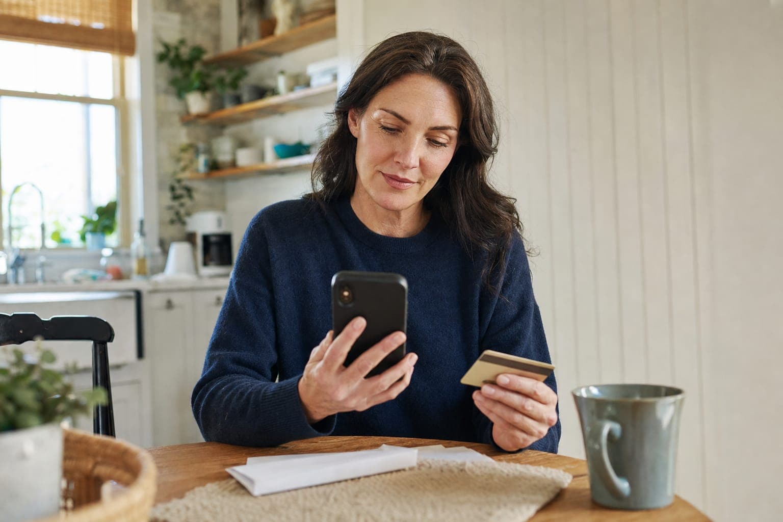 Tenant paying storage rent on her phone at the kitchen table